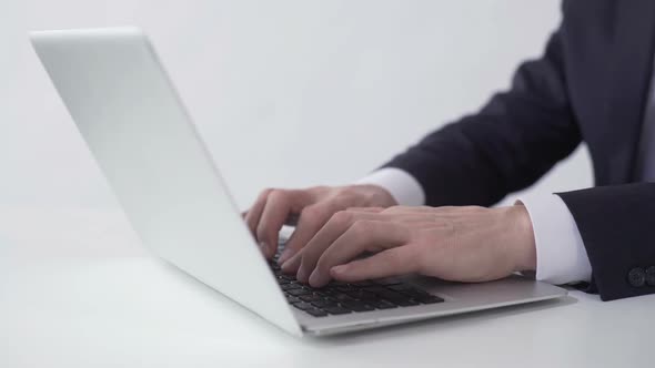 Man Typing and Sending Email to Business Partner on Laptop, Working in Office