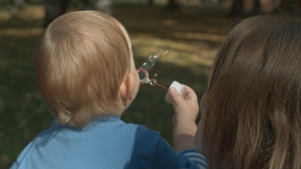 Cute Boy Blowing Soap Bubbles