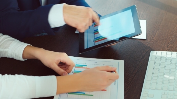 Two Pair Of Hands Working With Documents And