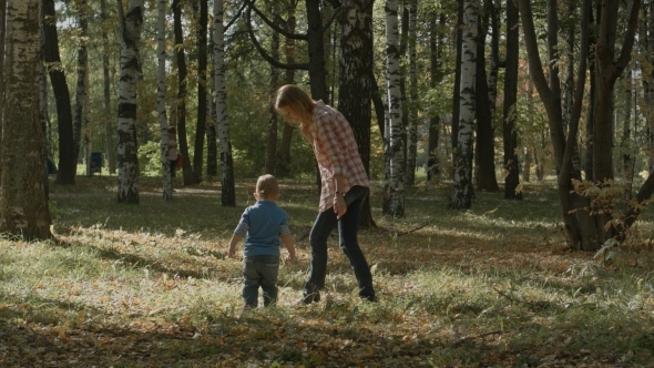 Mother With Son Walking Outdoor In Autumn