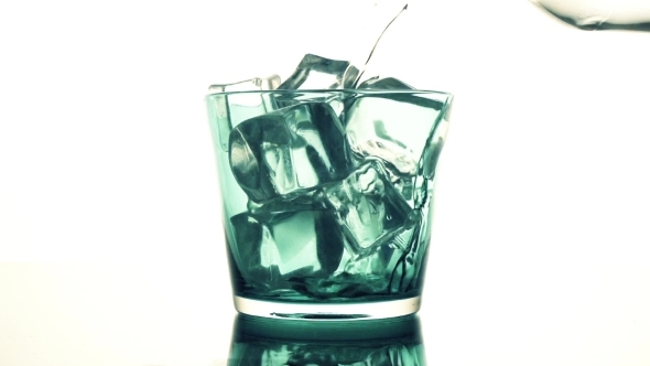 Water Pouring Into a Blue Glass With Ice Cubes