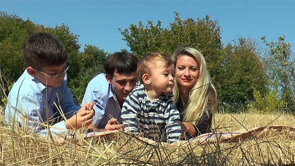 Family Lying in the Meadow Facing the Camera