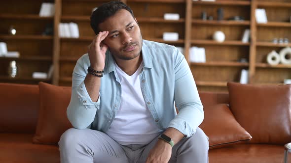 Indian Man Sits on the Sofa with Upset Face Expression