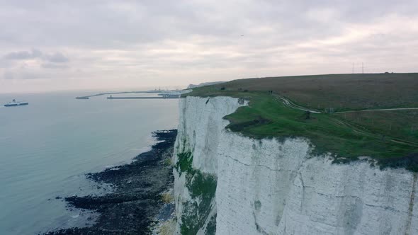 Low drone shot along muddy pathways on top of white cliffs of dover