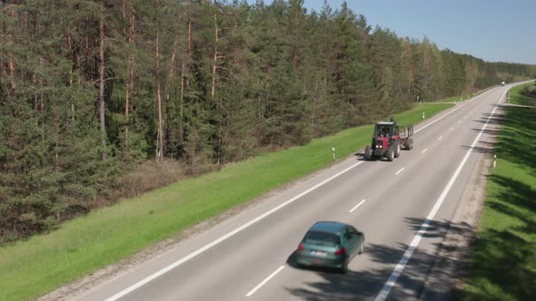 Farming Red Tractor Driving on Asphalt Road