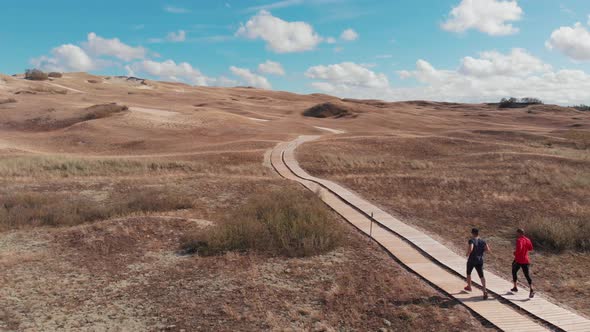 People running on path through dunes