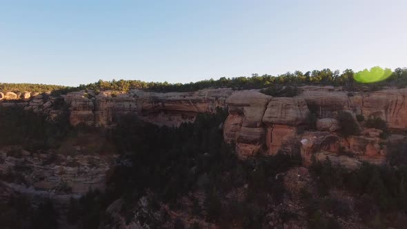 Aerial spinning shot exposing the green sunlit canyon in Mesa Verde National Park, Colorado, USA