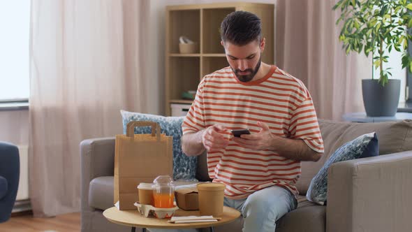 Man with Phone Checking Food Order at Home