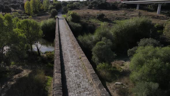 Roman stone bridge on Seda river at Vila Formosa In Portugal. Aerial tilt up reveal