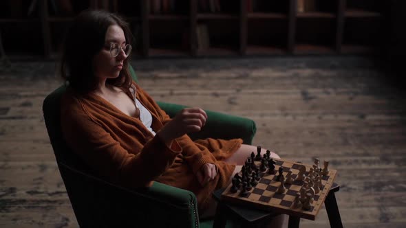 Highangle View of Serious Intelligent Female Chess Player in Glasses Making Move in Chess Game