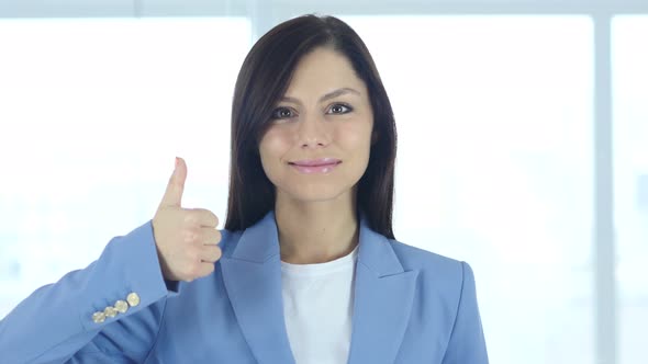 Thumbs Up by Young Businesswoman in Office