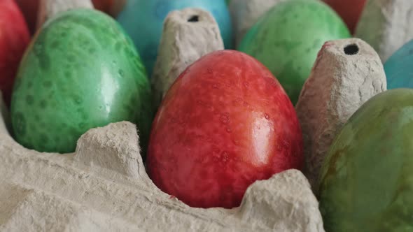 Red painted egg in carton 4K tilting video alt