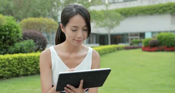 Woman using digital tablet at outdoor park