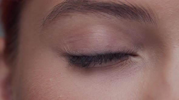 Close-up portrait of young, beautiful and natural woman opening her eyes.