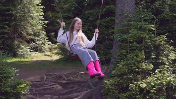 Girl on Swing in Forest.