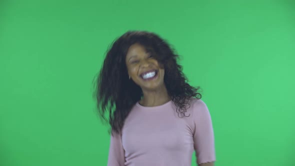 Portrait of Beautiful African American Young Woman Is Looking at Camera and Dancing Funny. Burning