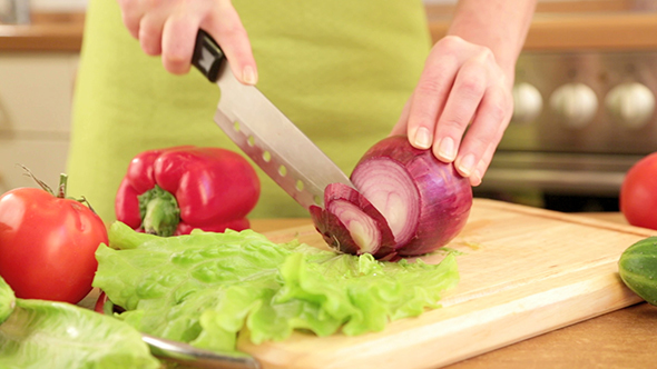 Woman's Hands Cutting Bulb Onion