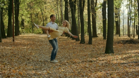 Young Man Spinning His Girl In a Circle In Autumn