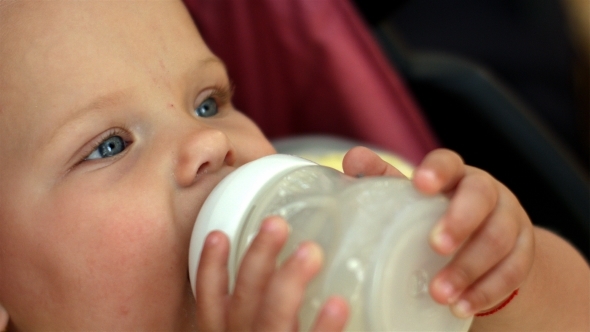 Lovely Little Girl With Blue Eyes Drinking Milk