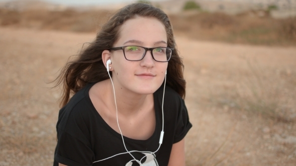 Teenage Girl Listening To The Music Outdoors