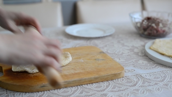 Woman's Hands Unroll a  Dough For Pelmeni