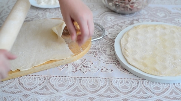Children's Hands Unroll a  Dough For Pelmeni