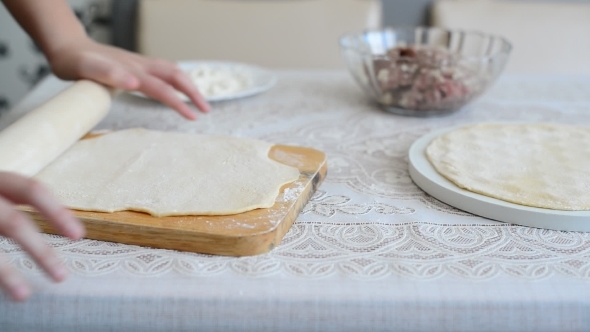 Children's Hands Unroll a  Dough For Pelmeni