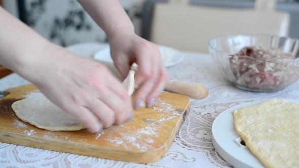 Woman's Hands Unroll a  Dough For Pelmeni