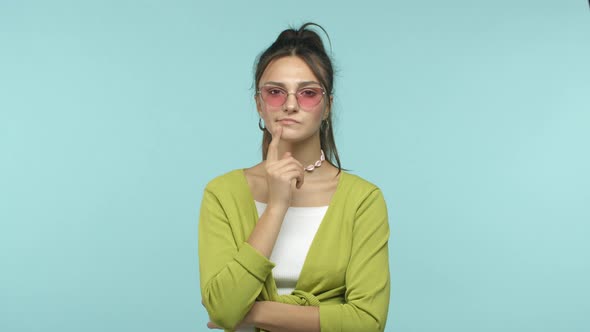Slow Motion of Stylish Brunette Woman in Sunglasses Looking Pensive Thinking and Raising Finger Up