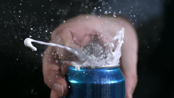 Rotating slow motion of aluminum can opening and spraying as tab is pulled