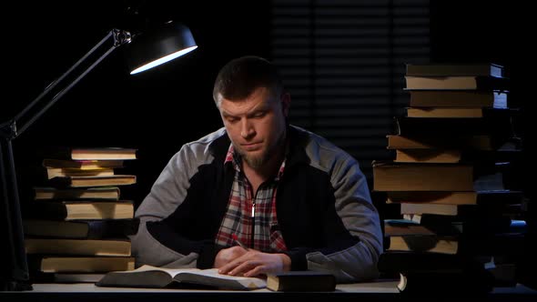 Man Takes a Book and Writes the Information Itself. Black Background