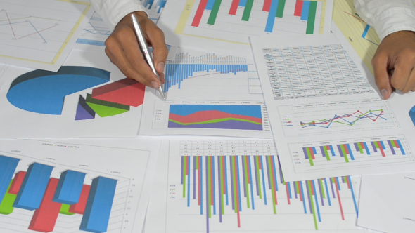 Man Working with Graphs and Financial Charts