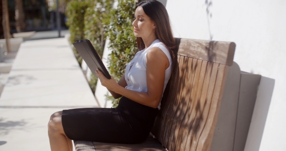 Smiling Young Woman Using Her Tablet Outdoors