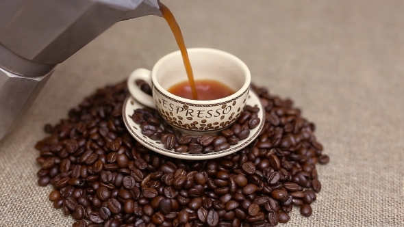 Pouring a Cup Of Coffee With Coffee Beans
