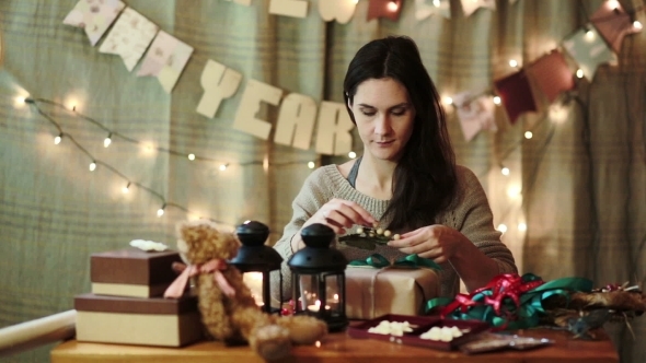 Young Woman Wrapping Christmas Gifts At Home