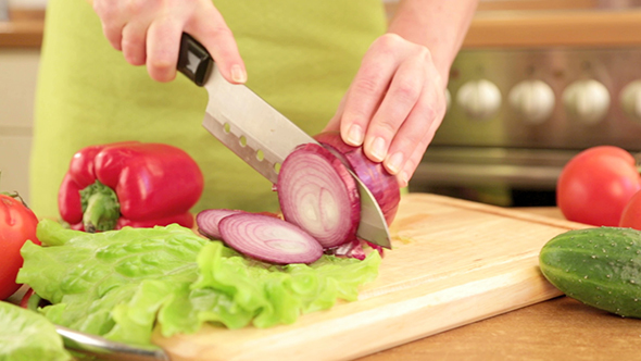 Woman's Hands Cutting Bulb Onion