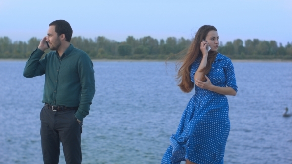 Man And Woman With Cell Phones Talking.