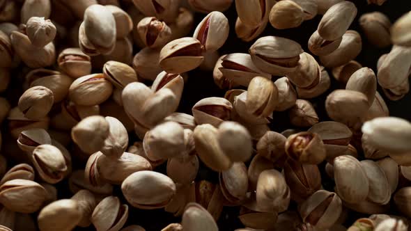 Super Slow Motion Shot of Pistachios Flies After Being Exploded Against Black Background 1000Fps