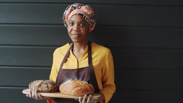 Portrait of Beautiful Afro-American Female Baker with Fresh Bread