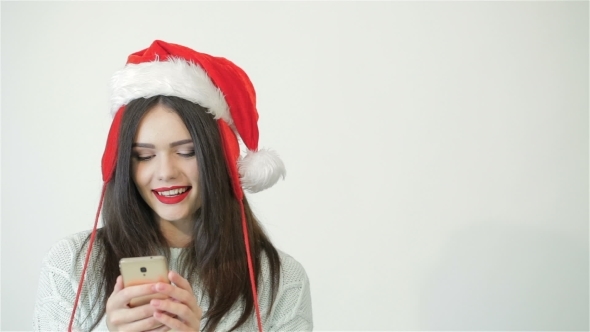 Girl In Santa Hat Using a Smartphone