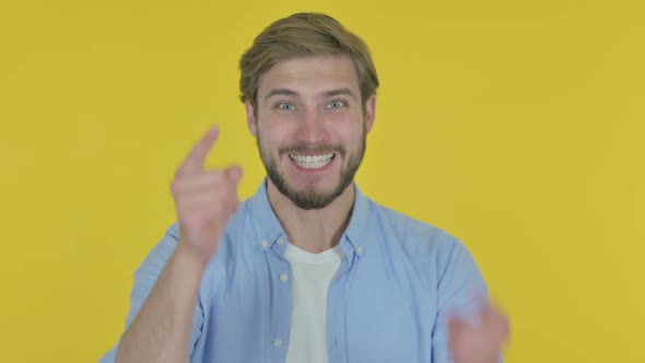 Angry Young Man Arguing on Yellow Background