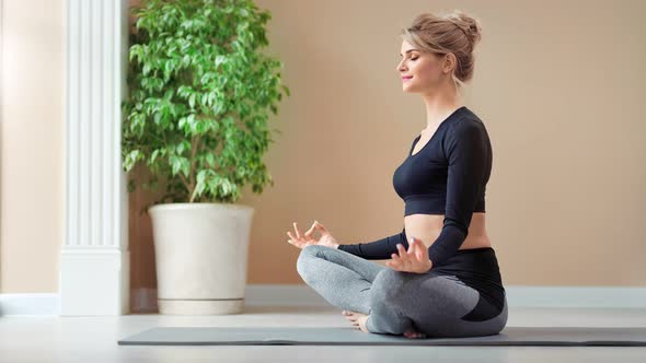 Smiling Pleasant Beautiful Girl Enjoying Meditation in Lotus Pose Relaxing at Studio Full Shot