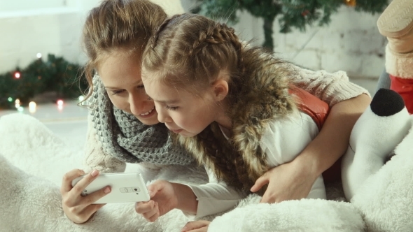 Two Girlfriends Looking At a Smartphone alt