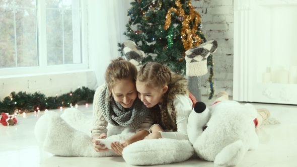 Two Girlfriends Looking At a Smartphone alt