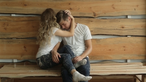 Young Couple On The Background Of Wooden Wall