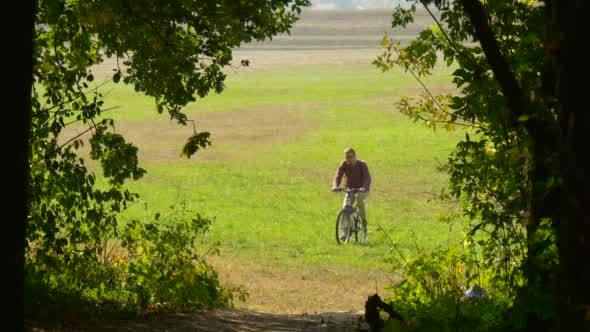 Man Rides On The Bicycle He Rises Up On The Hill