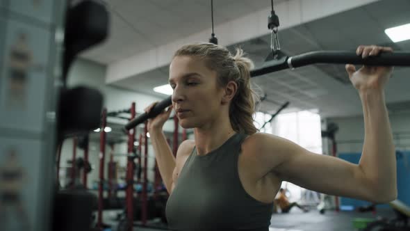 Young caucasian woman  exercising with weights  on a gym. Shot with RED helium camera in 8K.