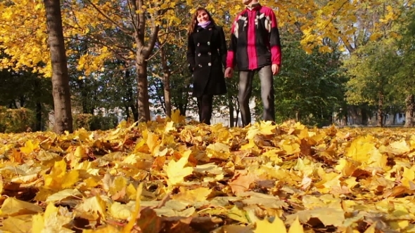 Young Man And Girl Walking In The Autumn Park