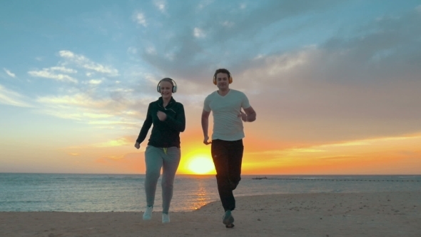 Young Couple Jogging On The Beach