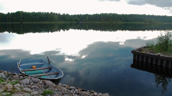 Stone Pier, Lake With Boat. Green Forest, Cloudy